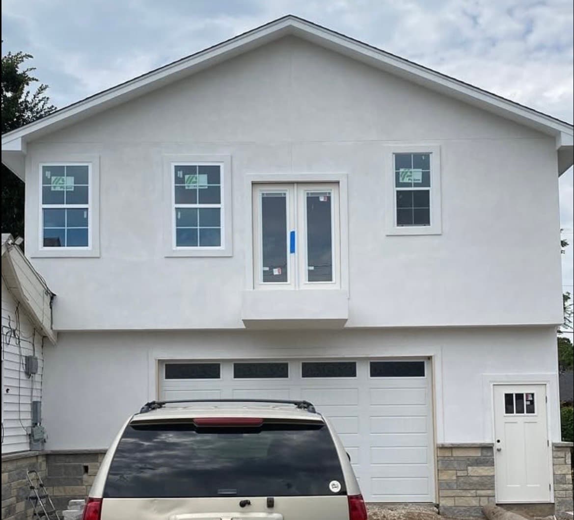 Two-story stucco garage addition with French doors above the garage door