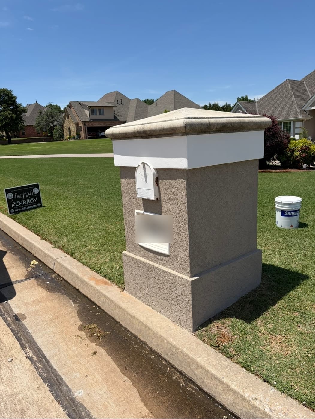 Stucco mailbox pillar with a cast stone cap