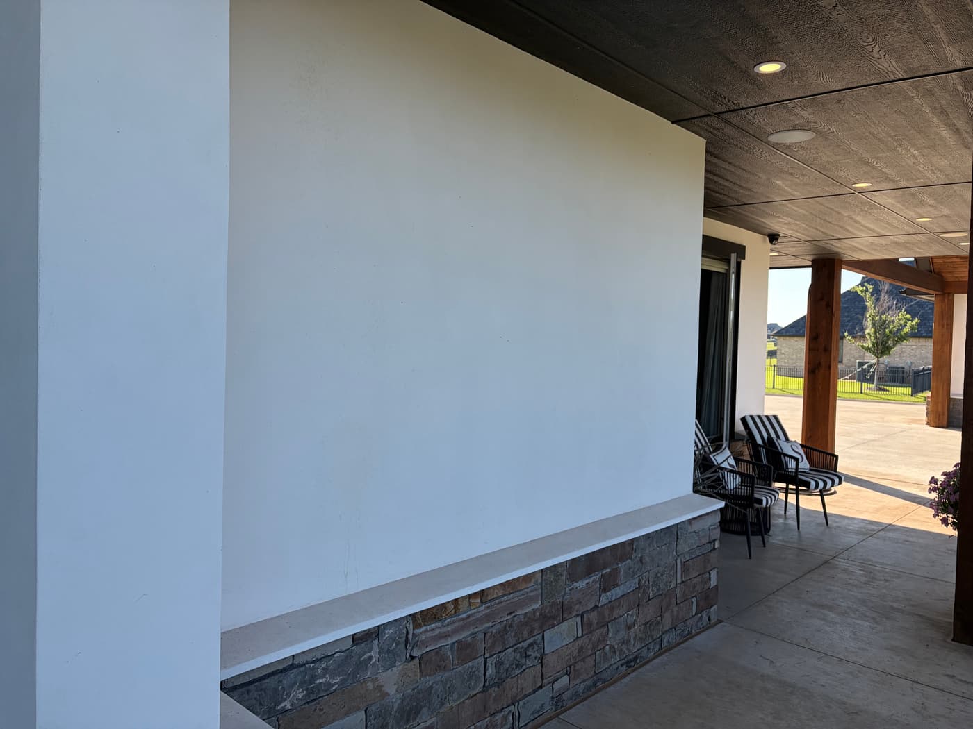 Smooth stucco patio wall above a stacked stone veneer base
