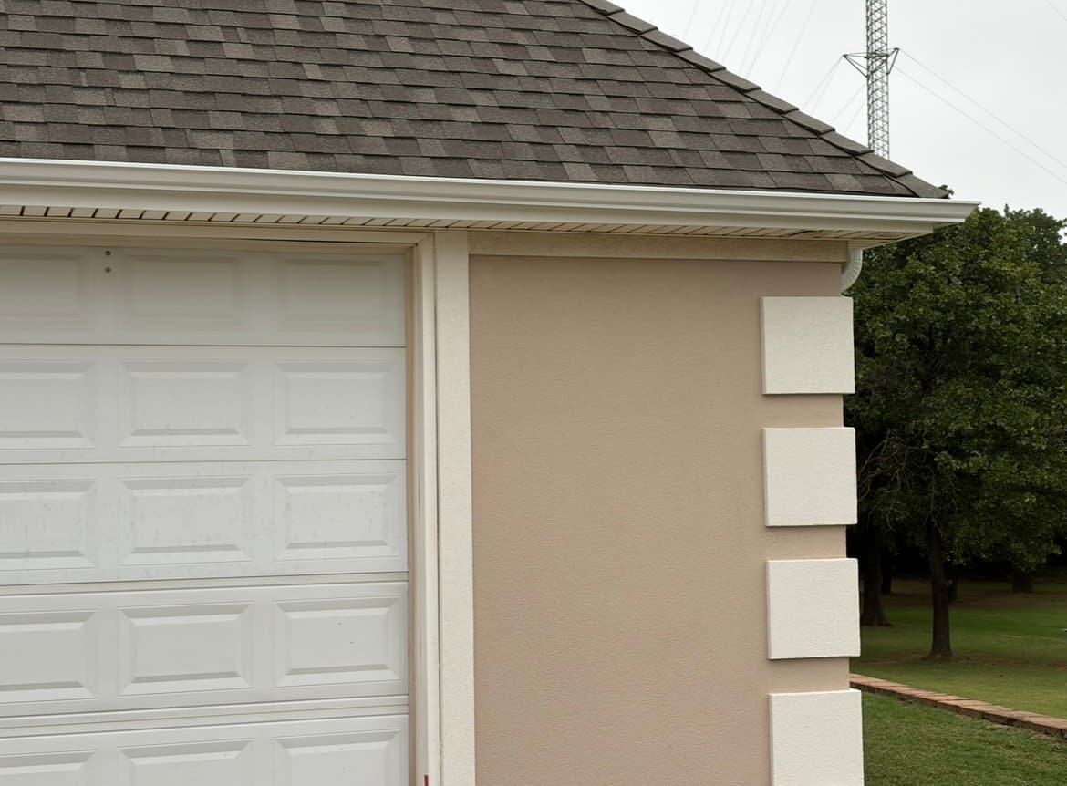 Close-up of white quoin details on a stucco garage corner